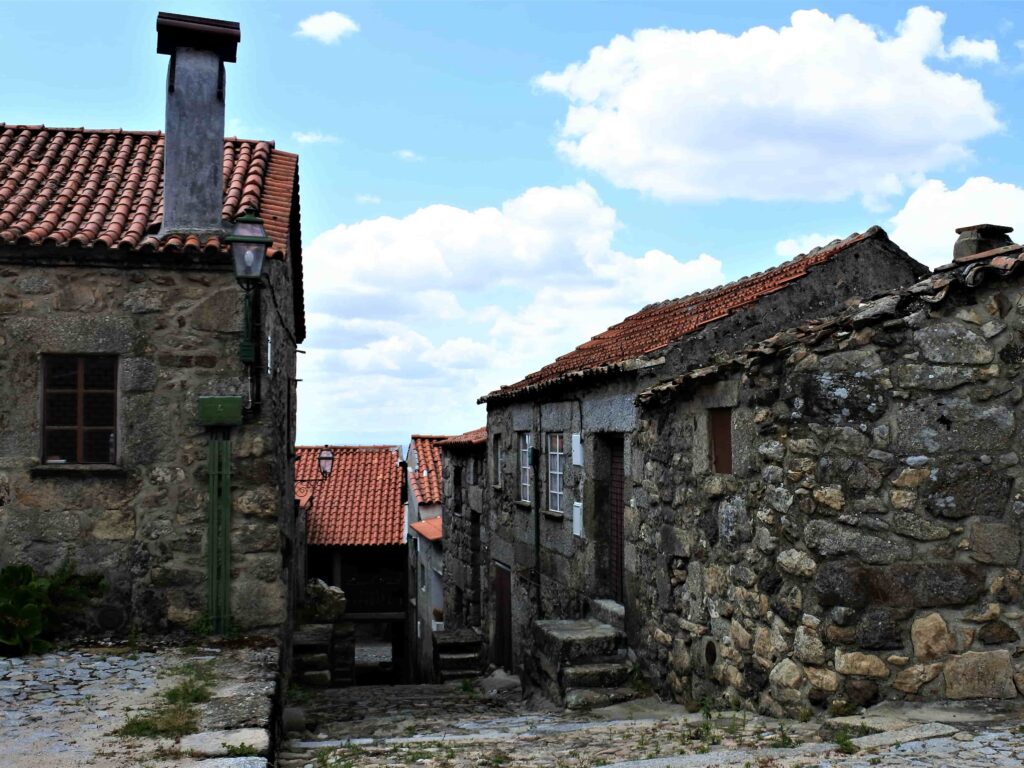 煙突のある家と石造りの家に囲まれる路地