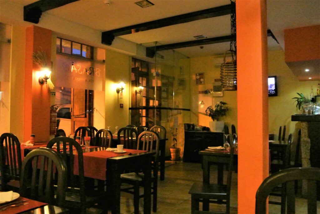 レストランO Brasao店内　オレンジ色の柱とオレンジ色のテーブルクロスの引かれた客席